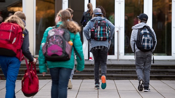 Schüler kommen am 06.04.2016 zum Gymnasium in Alsdorf (Nordrhein-Westfalen). Im Alsdorfer Gymnasium dürfen Schüler je nach Neigung früher oder später kommen.