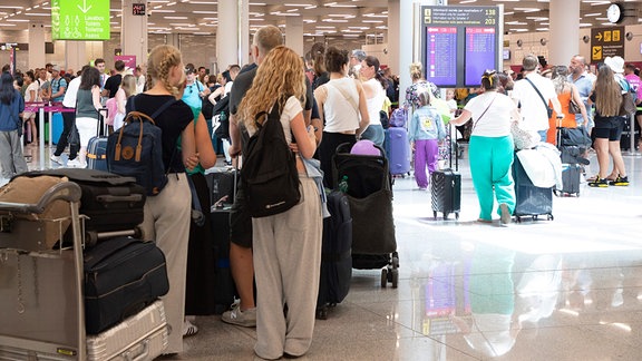 Passagiere warten auf dem Flughafen von Palma de Mallorca, wo es aufgrund einer weltweiten IT-Störung zu Flugausfällen und Verspätungen kommt.