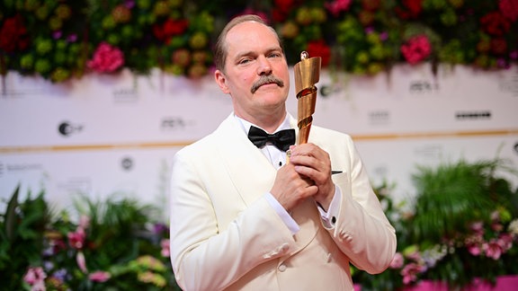 Schauspieler Godehard Giese, hält die Lola für die beste männliche Nebenrolle in "Sad Jokes" während der 75. Verleihung des Deutschen Filmpreises in Berlin im Theater am Potsdamer Platz. 