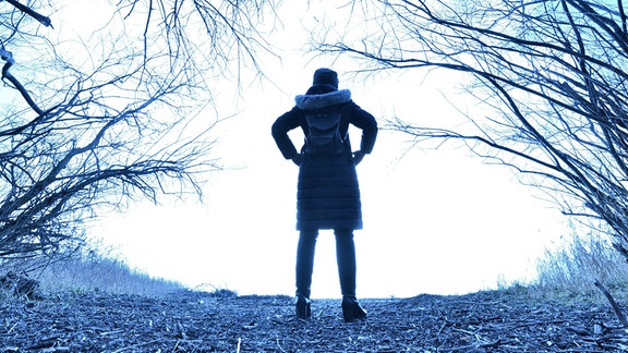 Eine Frau steht im Herbstwald