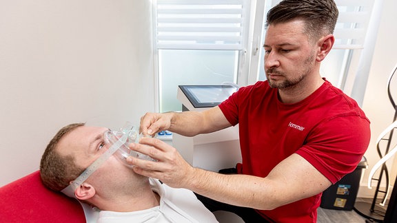 Pascal Sommer legt einem Patienten eine Sauerstoffmaske an.