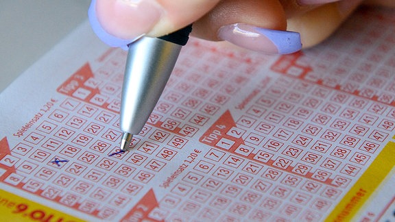 Eine Frau füllt einen Lottoschein aus. 