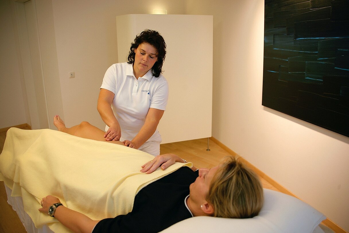 Physiotherapeutin führt Lymphdrainage an Patientin durch.