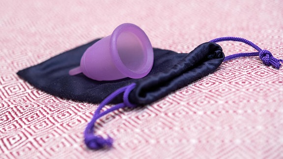 Eine lila Menstruationstasse