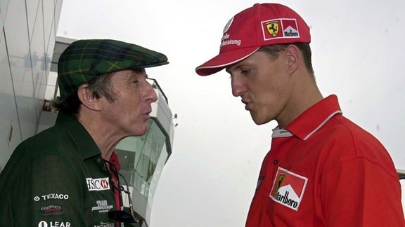 Die beiden dreifachen Weltmeister in der Formel 1, Jackie Stewart (l) und Michael Schumacher (r), diskutieren am Rande der Rennstrecke von Sepang bei Kula Lumpur.