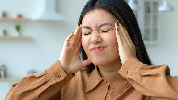 Frau mit Migräne Kopfschmerzen