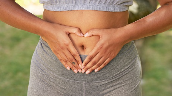 Frau hält die Hände vor ihren Bauch