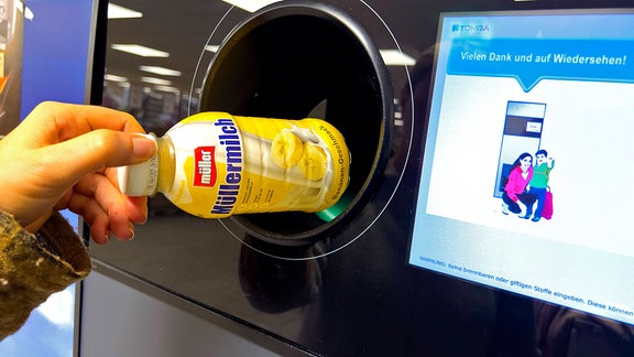 Plastikflasche für Milchgetränk wird am Pfandautomaten abgegeben.