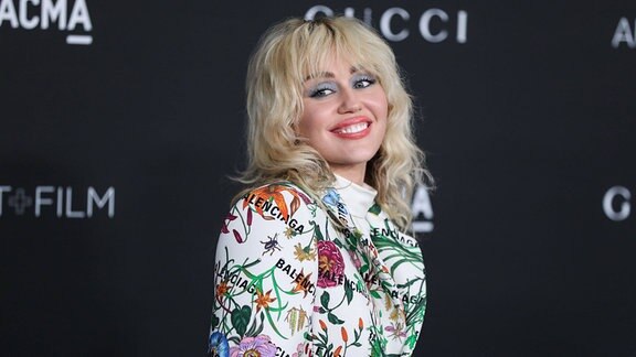 Miley Cyrus lächelt.