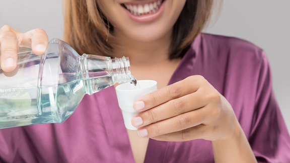 Frau verwendet Mundspühlung
