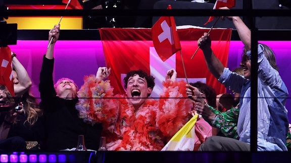 Nemo (M) aus der Schweiz reagiert während der Punktewertung beim Finale des Eurovision Song Contest (ESC) 2024 in der Malmö Arena.