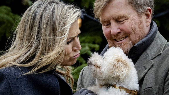 König Willem-Alexander und Königin Maxima schmusen mit ihrem Hund Mambo während der traditionellen Fotosession der königlichen Familie im Palast Huis ten Bosch.