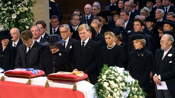 Prinzessin Laurentien, ihr Ehemann Prinz Constantijn, seine Mutter, die niederländische Königin Beatrix, ihr ältester Sohn Kronprinz Willem-Alexander und dessen Ehefrau Kronprinzessin Maxima, Beatrix' Schwester Prinzessin Irene und ihr Vater Prinz Bernhard der Niederlande beten während des Trauergottesdienstes am 15.10.2002 in der Nieuwe Kerk in Delft vor dem Sarg des verstorbenen Prinz Claus. 