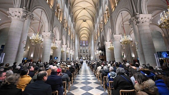 Gläubige versammeln sich während der ersten öffentlichen Messe in der Kathedrale Notre-Dame de Paris, wobei der Erzbischof von Paris die Weihe des neuen Hauptaltars vollzieht.