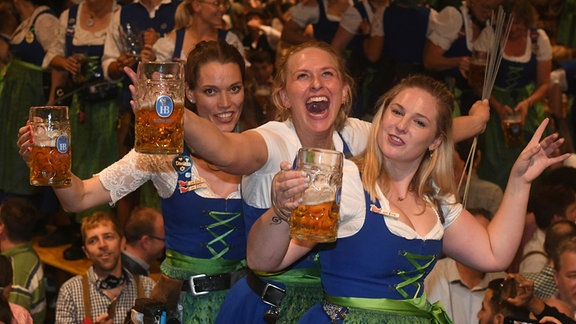 Bedienungen feiern mit den Gästen beim traditionellen Kehraus im Hofbräuzelt den Abschluss der Wiesn.