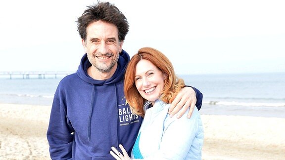 Oliver Mommsen und Katja Runge in Winterkleidung am Strand
