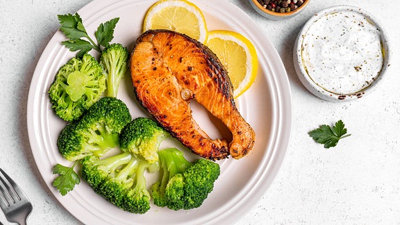 Gegrilltes Lachs-Fischsteak mit Brokkoli, auf einem Teller angerichtet