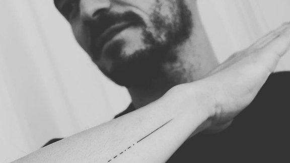 Orlando Bloom mit seinem neuen Tattoo, das er auf seinem Unterarm hat. Das Tattoo besteht aus Zahlen und einem Morsecode, in dem sich ein Fehler eingeschlichen hat.