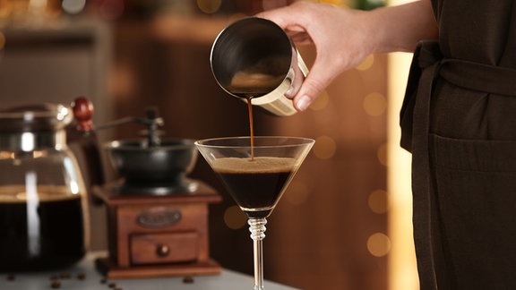 Frau bereitet Espresso Martini an der Bartheke zu