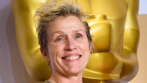 Schauspielerin Frances McDormand posiert mit einem Oscar.