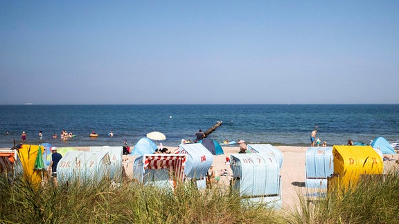 Badegäste im und am Strandkorb an der Ostsee von Kühlungsborn.