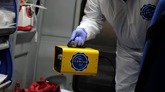 Ein Arbeiter hält einen gespendeten Ozongenerator, der zur Desinfektion verwendet wird.