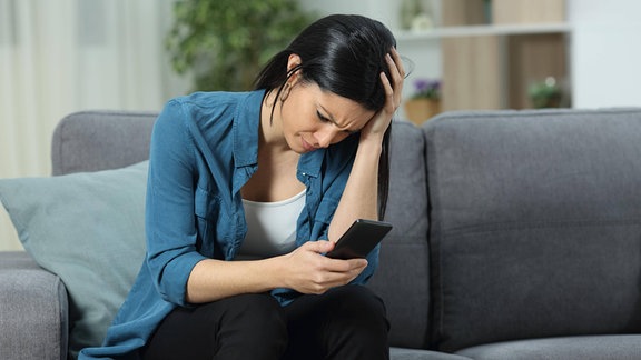 Besorgte Frau mit Smartphone