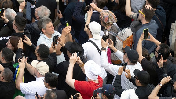 Menschen auf dem Petersplatz fotografieren mit ihren Smartphones den schwarzen Rauch, der am Mittag des zweiten Tages des Konklaves zur Wahl eines neuen Papstes aus dem Schornstein der Sixtinischen Kapelle kommt.
