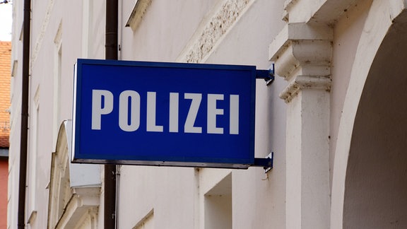Auf einem Schild über einem Eingang steht "Polizei".