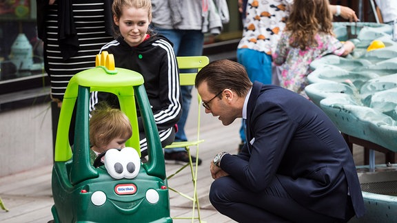 Kronprinz Daniel von Schweden spricht bei einem Besuch im Universitätskrankenhauses New Karolinska Solna mit einem kleinen Jungen