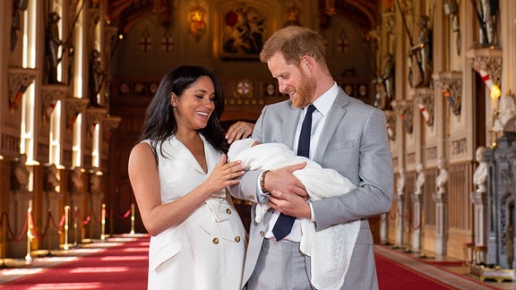 Prinz Harry und Herzogin Meghan halten ihren damals noch namenlosen Sohn (heute Archie Harrison Mountbatten-Windsor) in der St. George's Hall im Windsor Castle im Arm. 