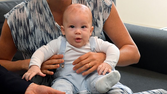 Archie, Sohn von Prinz Harry und Herzogin Meghan, sitzt während beim Besuch der Desmond & Leah Tutu Legacy Foundation, auf dem Schoß seiner Mutter.