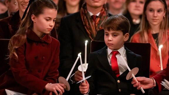 Die britische Prinzessin Charlotte und ihr Bruder Prinz Louis zünden während des Weihnachtsgottesdienstes "Together At Christmas" in der Westminster Abbey Kerzen an.