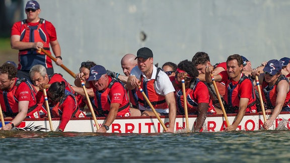 Der britische Prinz William (M) nimmt an einer Drachenbootveranstaltung teil.