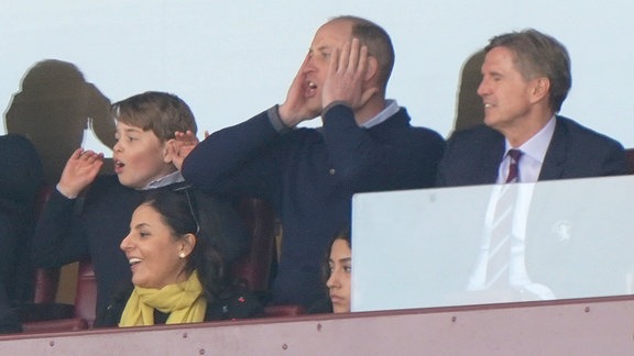 Prinz William und Prinz George verfolgen gespannt ein Fußballspiel.