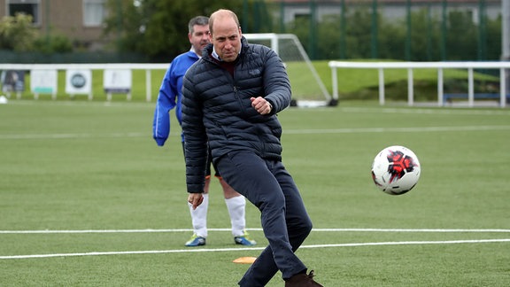 Prinz William, Herzog von Cambridge, kickt einen Ball während eines Besuchs im Ainslie Park Stadion des FC Spartans.