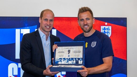 Der britische Prinz William (l)überreicht Spieler Harry Kane ein Geschenk während eines Besuchs im St. George's Park in Burton upon Trent, Staffordshire, wo er sich mit der englischen FuÃballnationalmannschaft vor der UEFA-Europameisterschaft 2024 trifft.