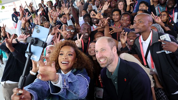 Der britische Prinz William (vorn, r) und die südafrikanische Schauspielerin Nomzamo Mbatha posieren für ein Selfie, während sie junge Umweltschützer aus ganz Afrika und Südostasien treffen, die am ersten Earthshot Prize Climate Leaders Youth Programme teilnehmen, im Rooftop on Bree. 