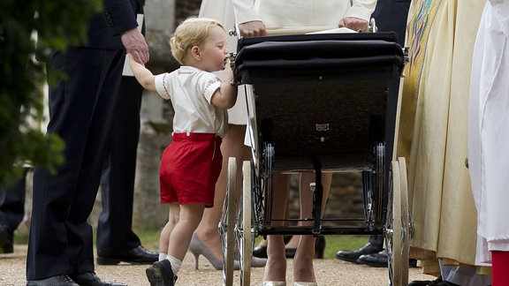 Prinz George schaut in den Kinderwagen seiner Schwester Chalotte. 