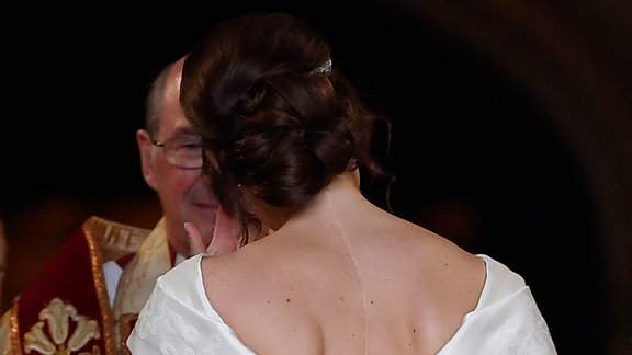 Prinzessin Eugenie kommt als Braut in Begleitung ihres Vaters zu ihrer Hochzeit an der St.-Georges-Kapelle von Schloss Windsor an. Am Rücken ist eine Narbe von einer Skoliose-Operation im Alter von 12 Jahren sichtbar.