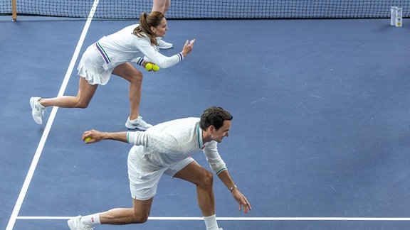 Dieses undatierte vom Kensington Palace herausgegebenes Foto zeigt Kate (hinten), Prinzessin von Wales, und Roger Federer, Tennis-Profi aus der Schweiz und achtfacher Wimbledon-Sieger, in Aktion auf den AELTC Indoor Tennis Courts während die Prinzessin im All England Lawn Tennis Club in Wimbledon einen Blick hinter die Kulissen der Arbeit der Balljungen und Ballmädchen wirft.