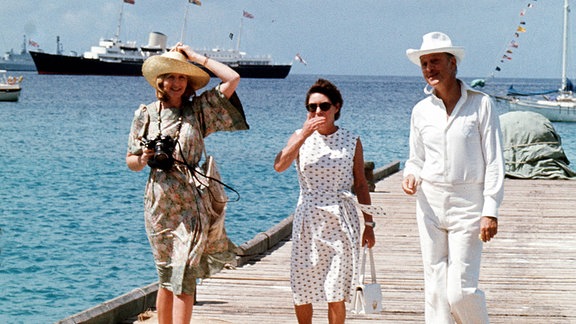 Prinzessin Margaret (c) und ihre Freunde Lady Ann Tennant und Colin Tennant warten auf der Karibikinsel Mustique auf dem Steg, um die Königin zu begrüßen, 1977.