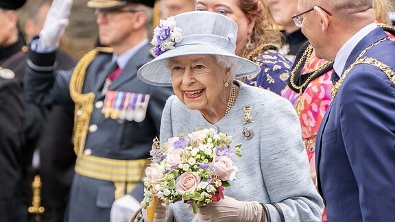 Königin Elizabeth II. hält einen Strauß Blumen in ihrer Hand, als sie im Vorplatz des Palastes von Holyroodhouse an der Ceremony of the Keys teilnimmt.2022