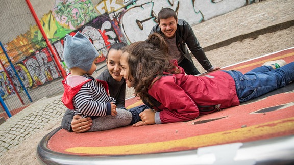 Eine Familie spielt am 26.10.2021 auf einem Spielplatz in Berlin (gestellte Szene).