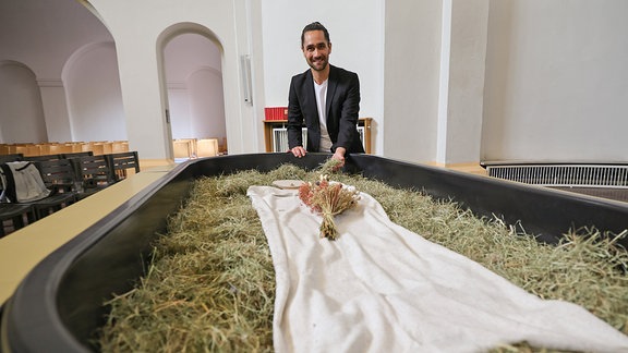 Ein Mann hinter einem sogenannten Kokon für die neue Bestattungsform Reerdigung