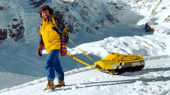 Strahlend zieht Reinhold Messner bei einer Wanderung bei Sulden in den Südtiroler Bergen einen von Opel entwickelten Hightech-Schlitten, den er von dem Rüsselsheimer Autohersteller erhalten hat (Aufnahme vom Dezember 1999). 
