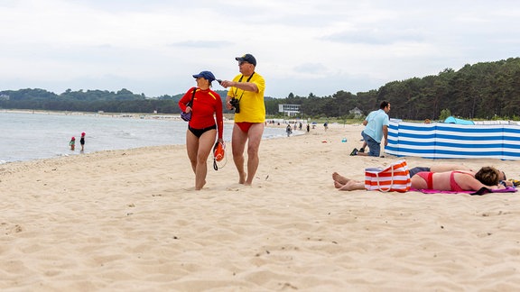 Zwei Rettungsschwimmer patrouillieren am Strand in Sellin