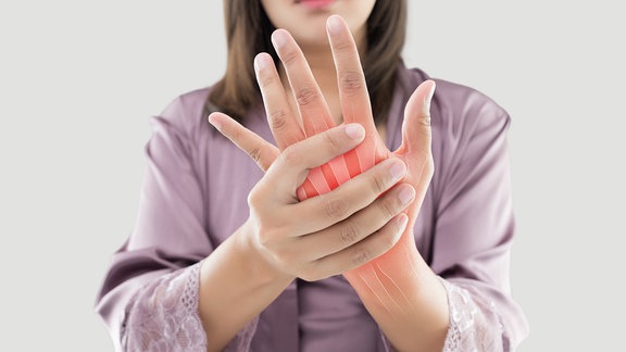 Frau hält schmerzende Hand