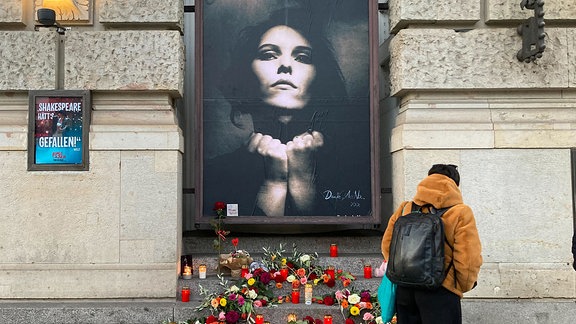 Eine Frau betrachtet einen Gedenkort für die verstorbene Rosenstolz-Sängerin Anna R. am Theater des Westens.