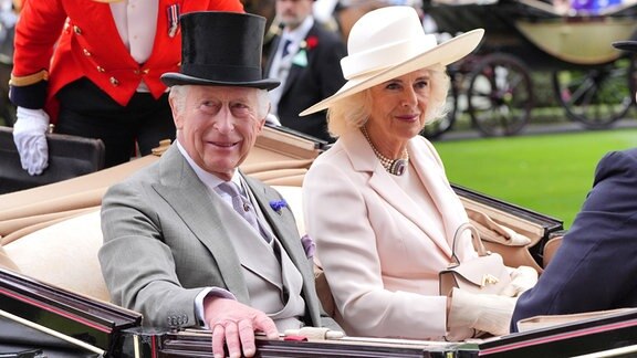König Charles III. und Königin Camilla von Großbritannien kommen am fünften Tag der Royal-Ascot-Rennwoche auf der Pferderennbahn von Ascot in einer offenen Kutsche an